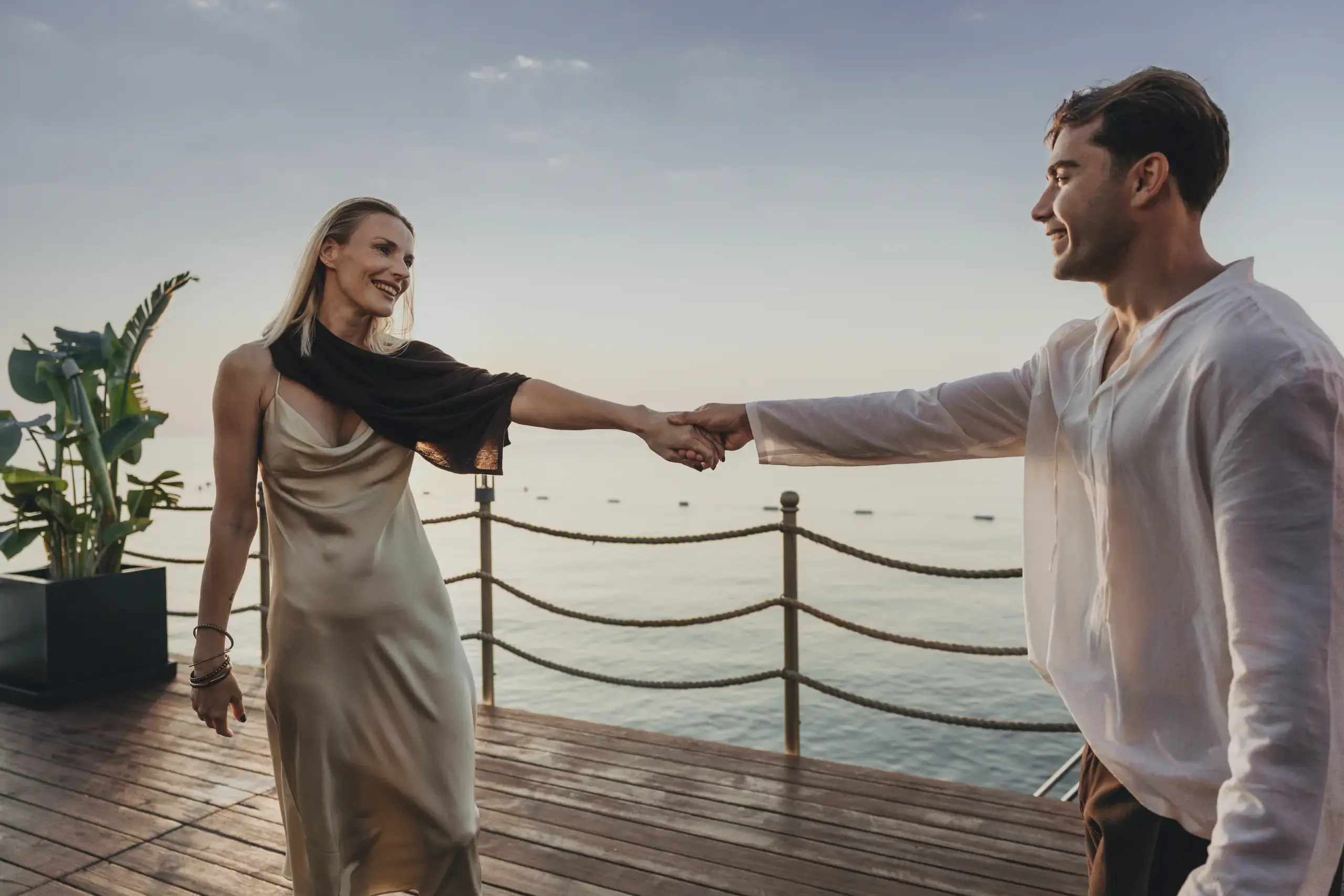 Gün batımında iskelede dans eden çift